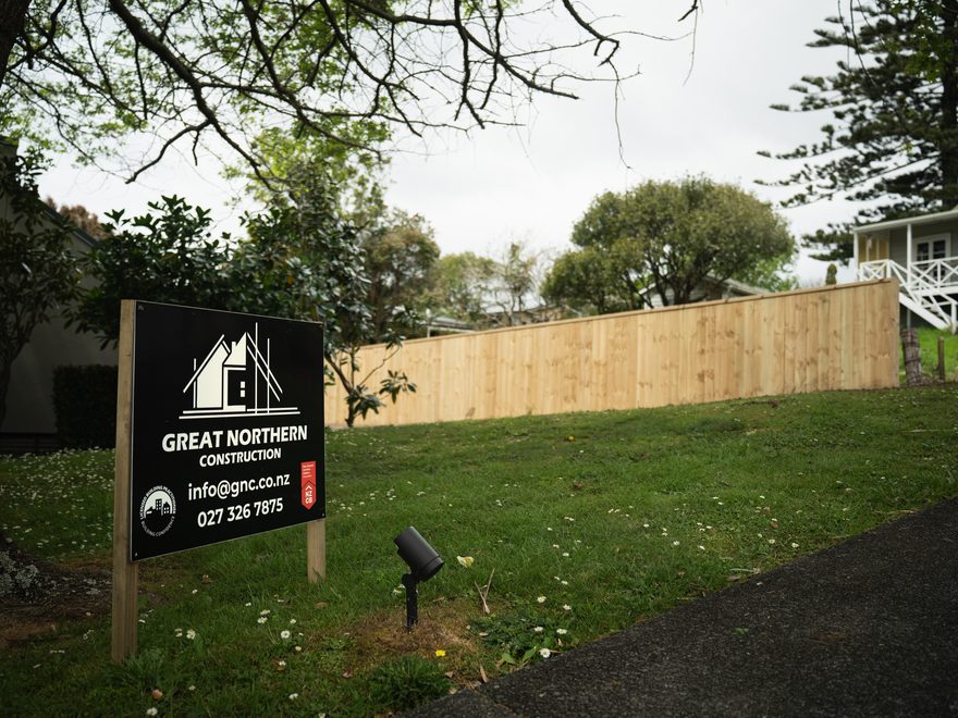 Great Northern Construction site sign on a lawn, with a newly built timber paling fence behind