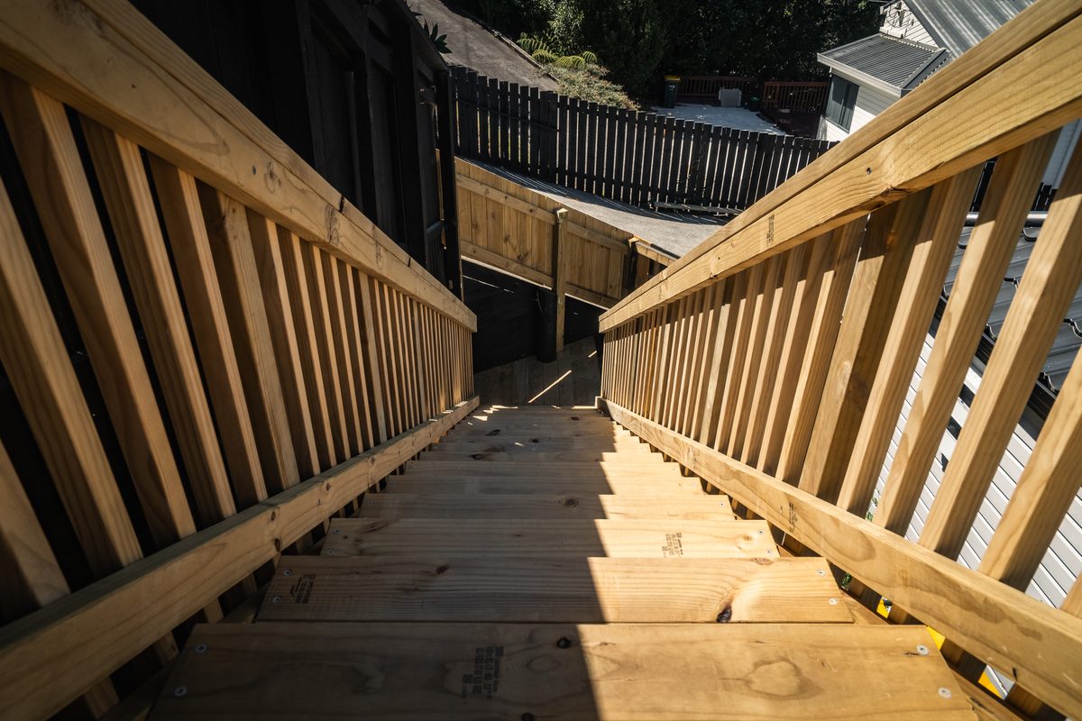 New timber stairs with vertical balustrades running down beside a house